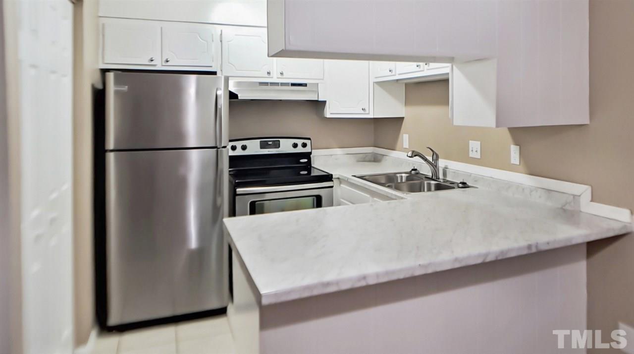 5804 Falls Of Neuse Road, Unit A Raleigh, NC 27609 - Photo 3 of 9 a kitchen with stainless steel appliances a refrigerator sink and stove