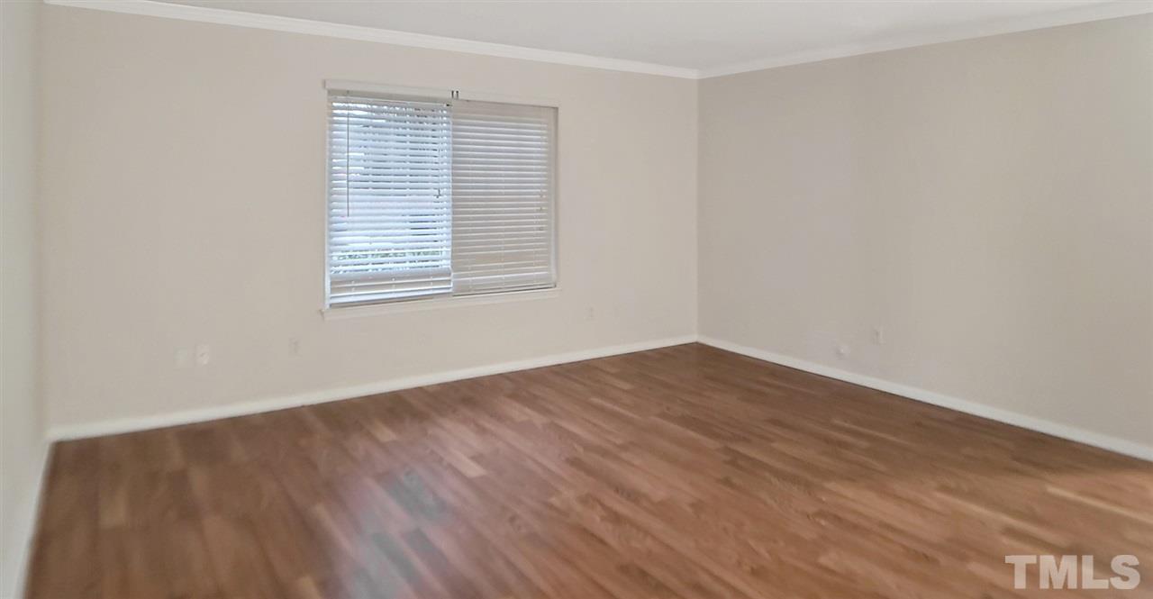 5804 Falls Of Neuse Road, Unit A Raleigh, NC 27609 - Photo 5 of 9 an empty room with wooden floor and windows