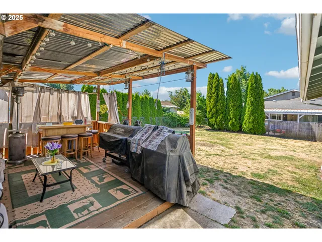 a backyard of a house with barbeque oven table and chairs