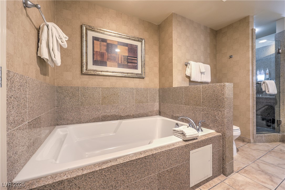 211 East Flamingo Road, Unit 1508 Las Vegas, NV 89169 - Photo 23 of 40 Bathroom featuring tile walls, a garden tub, and a stall shower
