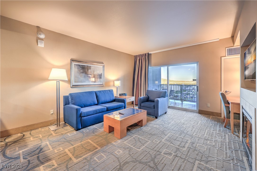 211 East Flamingo Road, Unit 1508 Las Vegas, NV 89169 - Photo 4 of 40 Living room featuring carpet flooring and a tiled fireplace