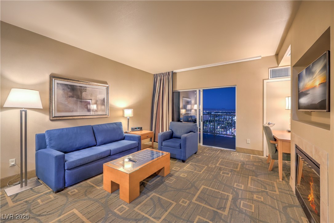 211 East Flamingo Road, Unit 1508 Las Vegas, NV 89169 - Photo 5 of 40 Carpeted living room featuring a tiled fireplace and baseboards