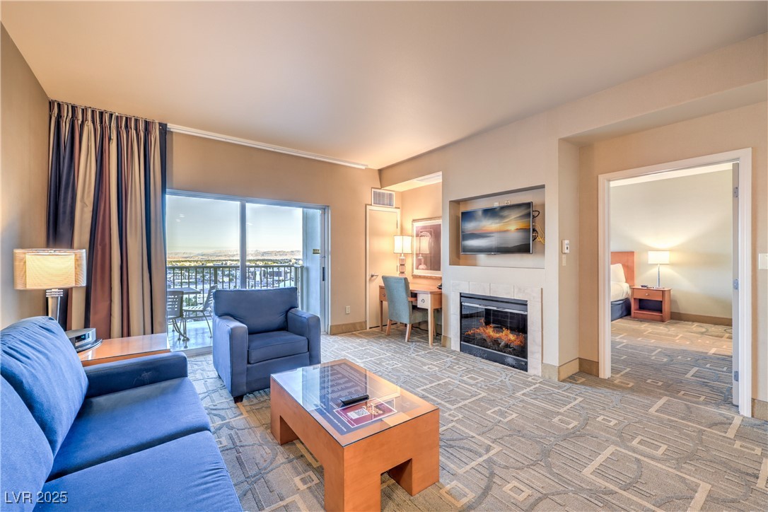 211 East Flamingo Road, Unit 1508 Las Vegas, NV 89169 - Photo 6 of 40 Carpeted living room featuring a tile fireplace and baseboards