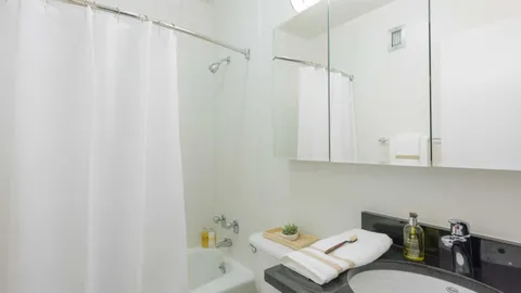 a kitchen with white cabinets a sink and a stove with wooden floor