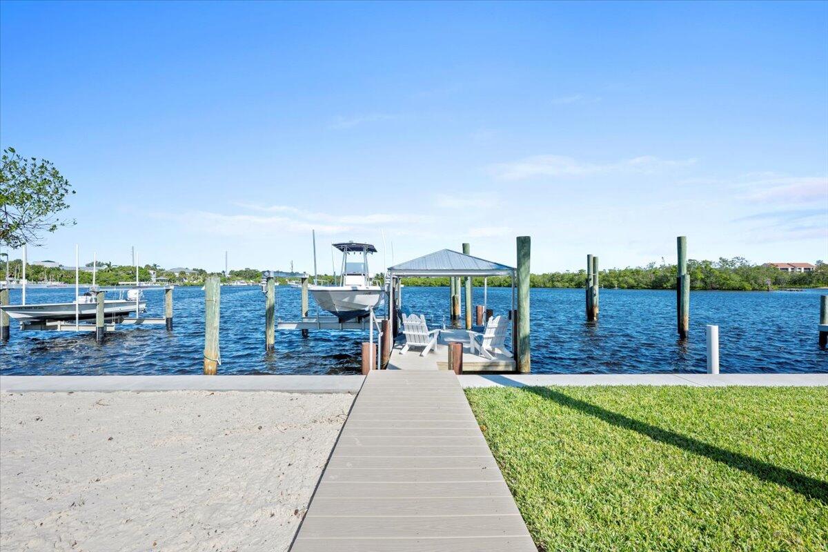 119 Elsa Road Jupiter, FL 33477 - Photo 8 of 38 a view of a swimming pool with a lawn chairs and couches