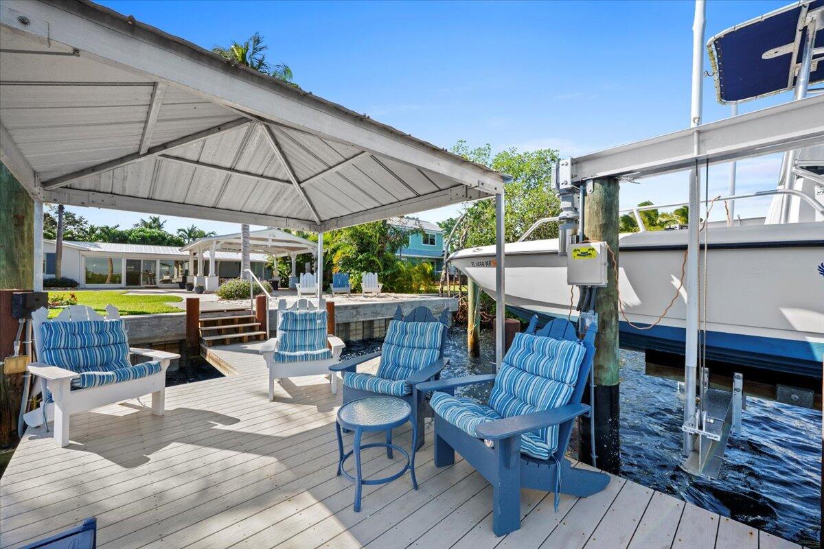 119 Elsa Road Jupiter, FL 33477 - Photo 9 of 38 a view of deck with table and chairs under an umbrella