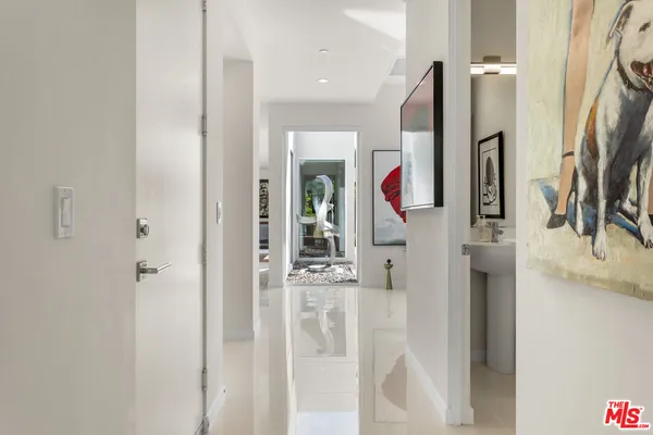 a hallway with painting and a potted plant