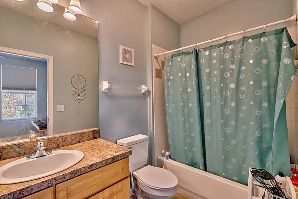 a bathroom with a granite countertop sink toilet a mirror a vanity and shower