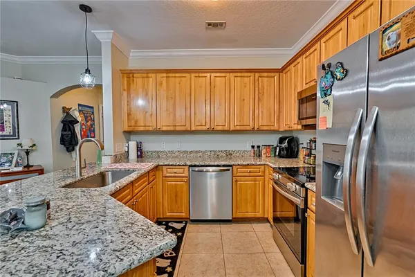 a kitchen with stainless steel appliances granite countertop a sink stove and refrigerator