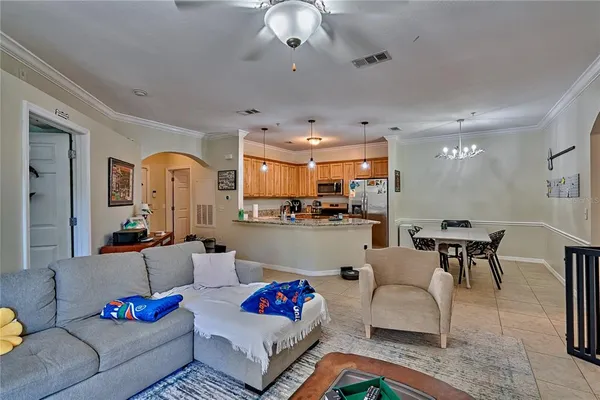 a living room with furniture kitchen view and a chandelier