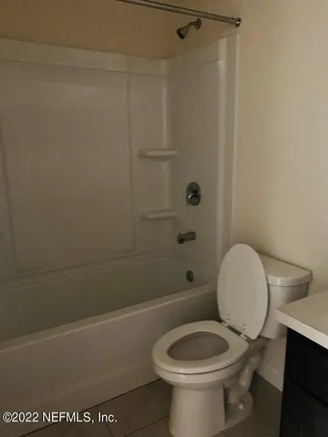 a white toilet sitting next to a bath tub and a shower