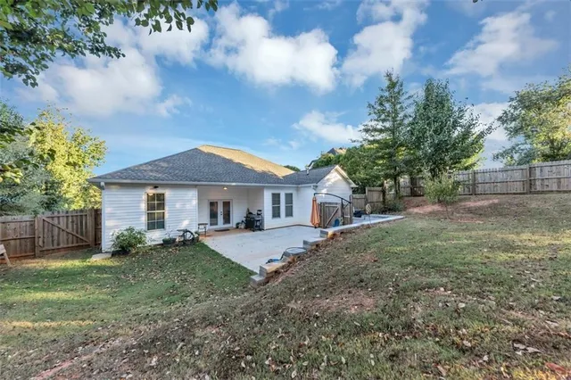 a view of a yard in front of a house with large trees