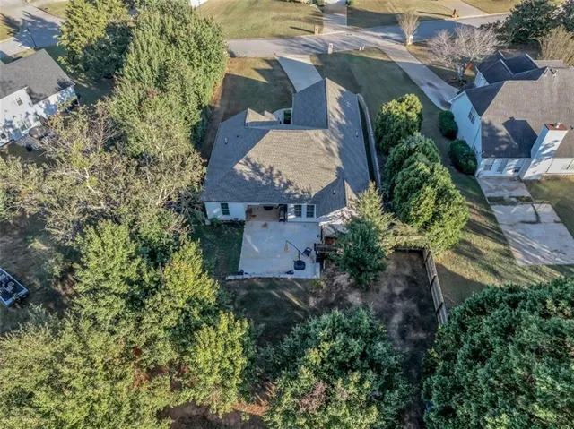 an aerial view of a house with a yard and trees