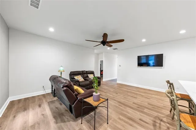 a living room with furniture and a wooden floor