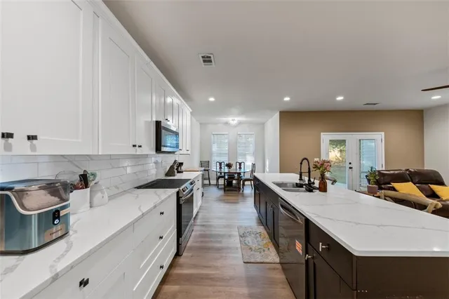 a kitchen with sink a stove and cabinets