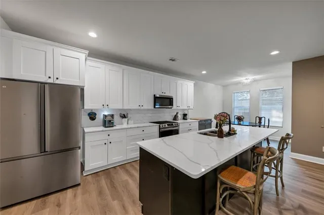 a kitchen with a refrigerator a stove a sink dishwasher and a refrigerator with wooden floor