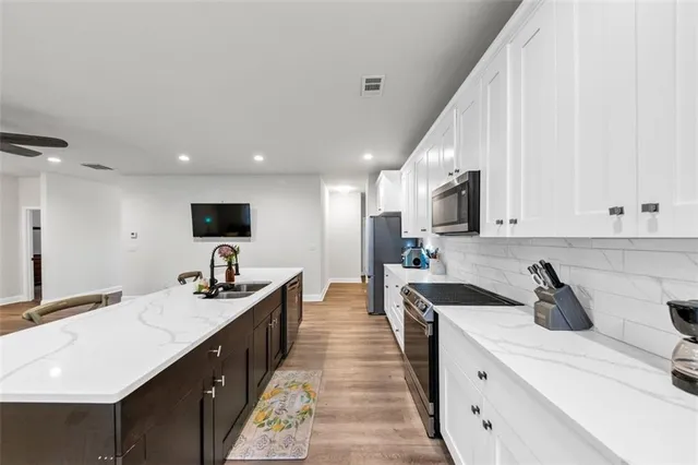 a kitchen with stainless steel appliances a sink stove and cabinets