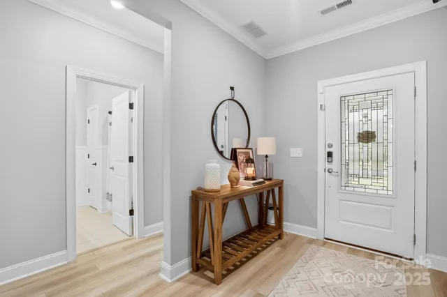 a kitchen with stainless steel appliances granite countertop a stove a refrigerator a kitchen island a sink dishwasher a dining table and chairs with wooden floor