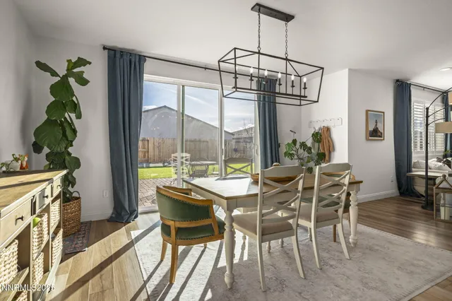 a dining room with furniture a chandelier and wooden floor
