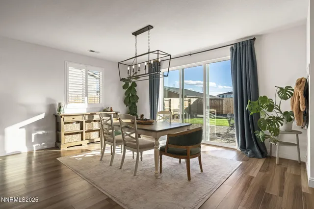 a dining room with furniture a chandelier and wooden floor