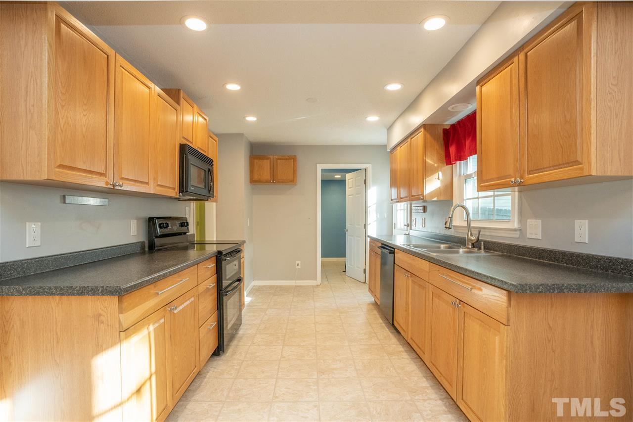 7300 Mine Shaft Road Raleigh, NC 27615 - Photo 10 of 22 a large kitchen with stainless steel appliances granite countertop a sink and cabinets