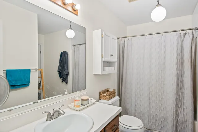 a bathroom with a sink vanity mirror and toilet