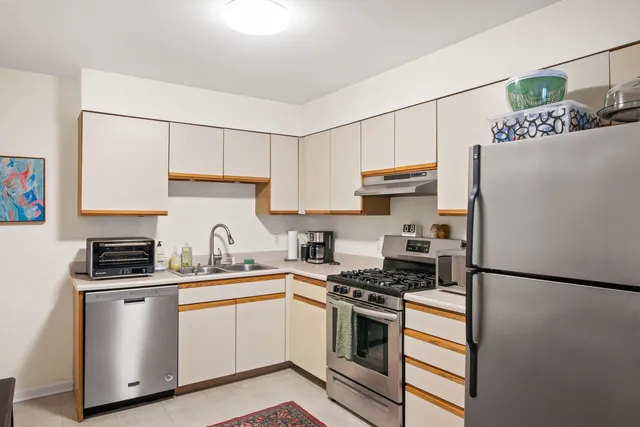 a kitchen with stainless steel appliances a refrigerator sink and stove top oven