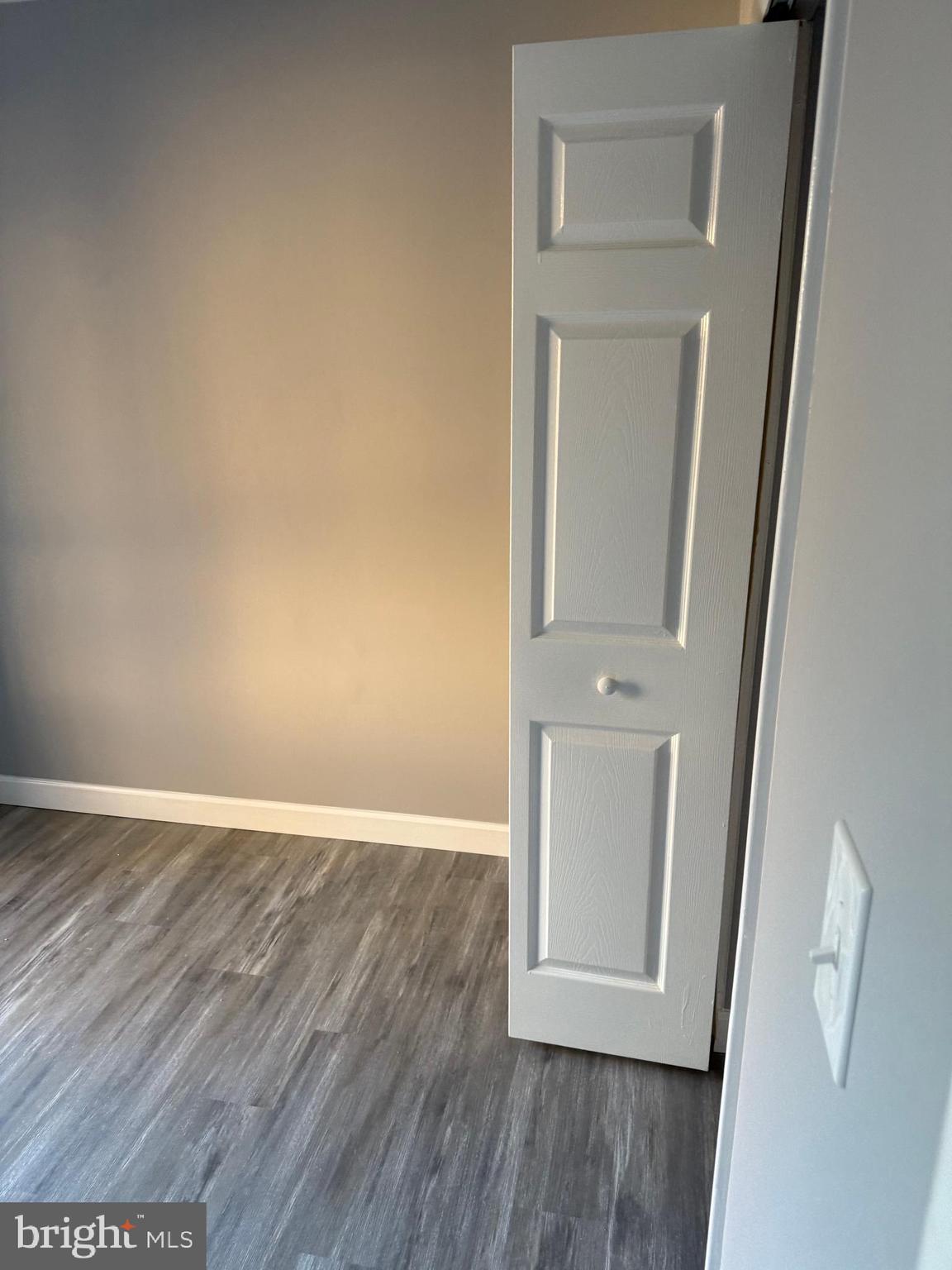 6029 Majors Lane, Unit 4 C16 Columbia, MD 21045 - Photo 13 of 51 an empty room with wooden floor and mirror