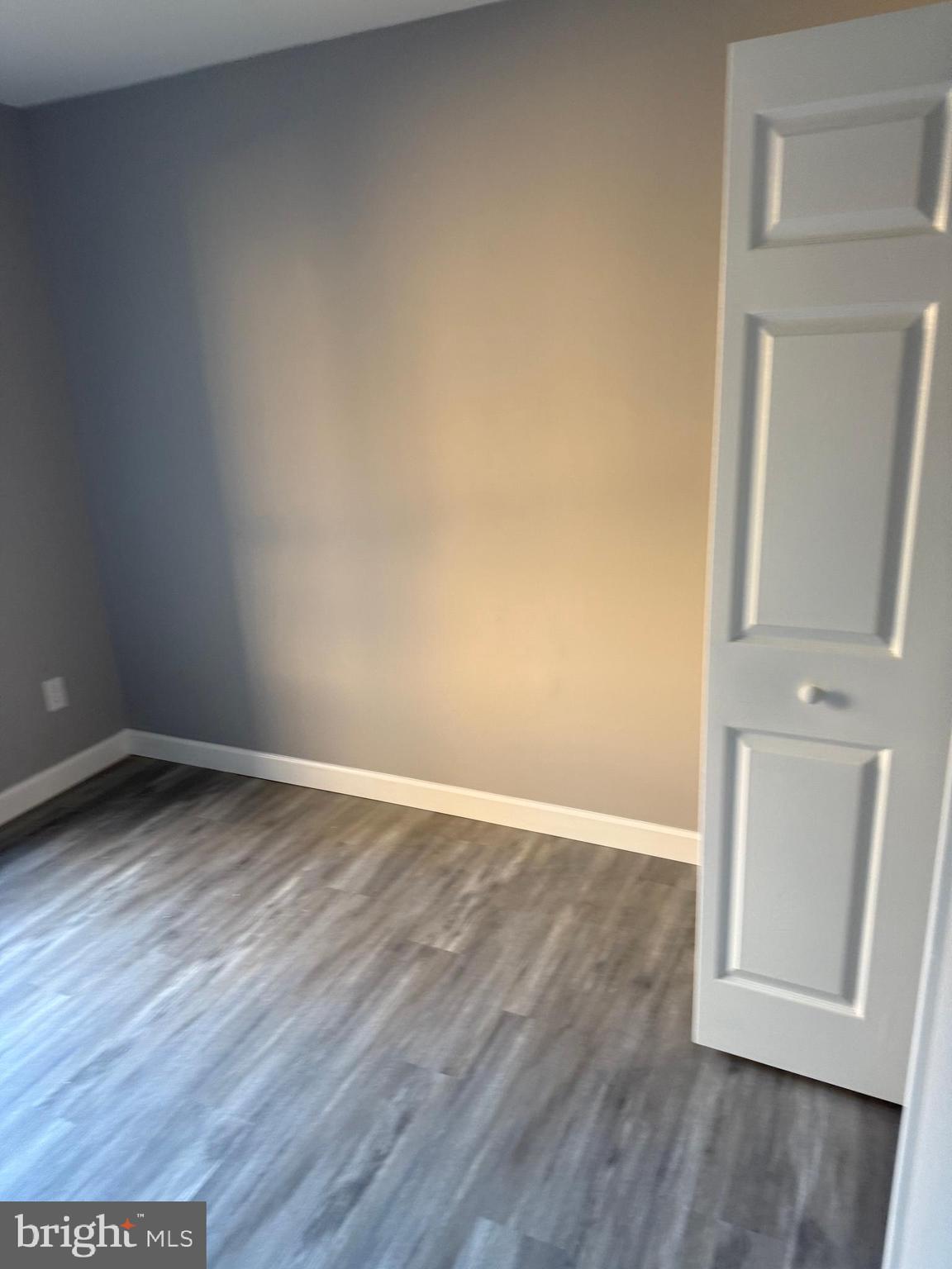 6029 Majors Lane, Unit 4 C16 Columbia, MD 21045 - Photo 14 of 51 an empty room with wooden floor and mirror