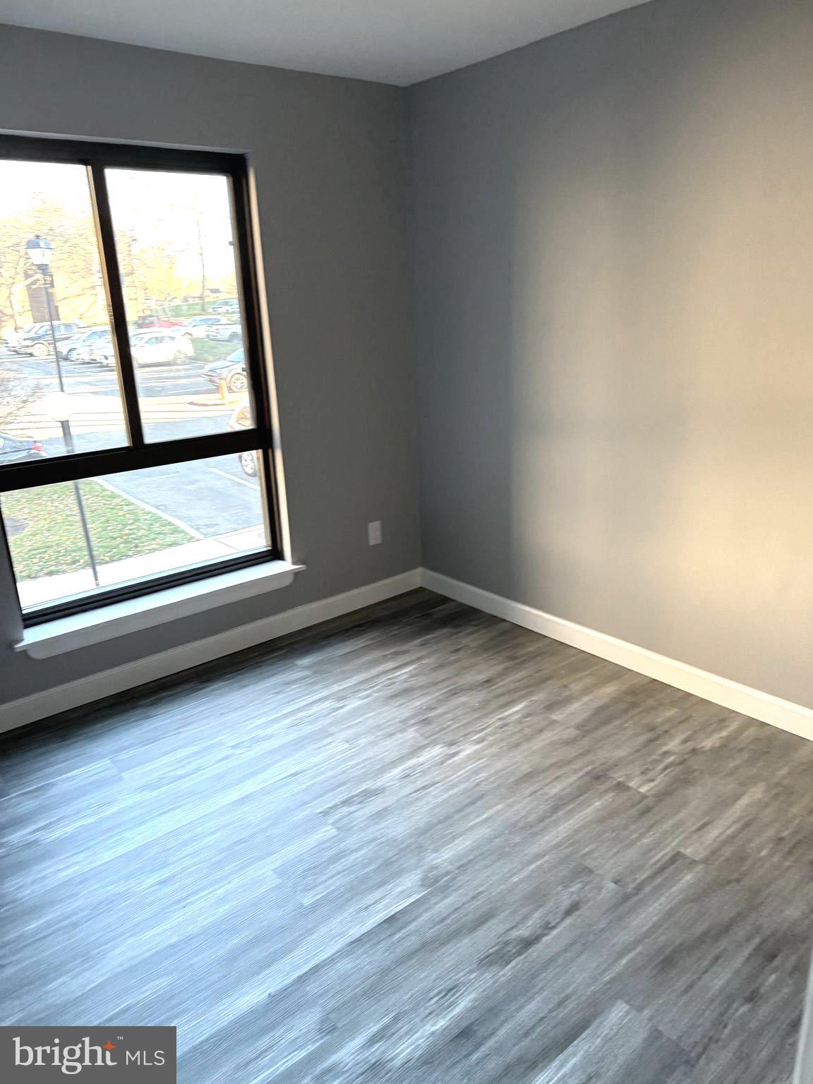 6029 Majors Lane, Unit 4 C16 Columbia, MD 21045 - Photo 15 of 51 a view of an empty room with wooden floor and a window