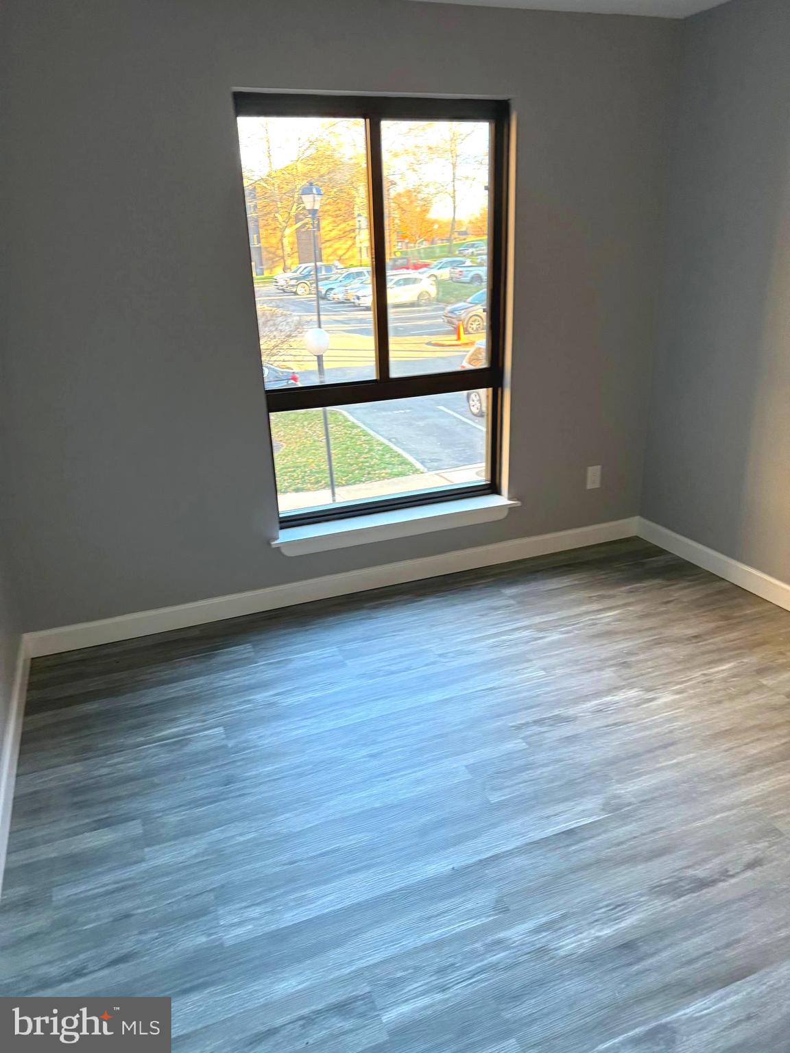 6029 Majors Lane, Unit 4 C16 Columbia, MD 21045 - Photo 16 of 51 a view of an empty room with wooden floor and a window