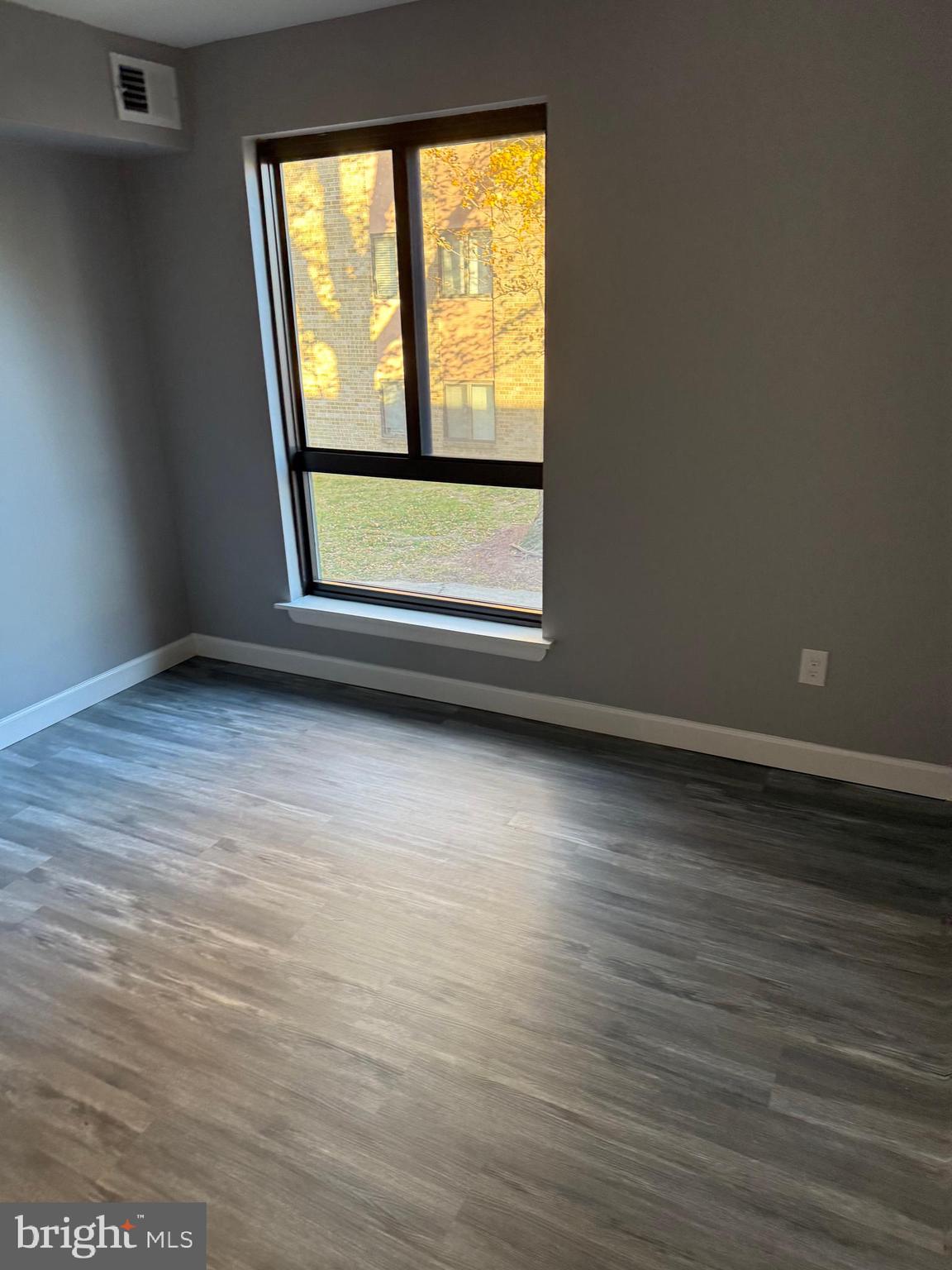6029 Majors Lane, Unit 4 C16 Columbia, MD 21045 - Photo 21 of 51 a view of an empty room with wooden floor and a window