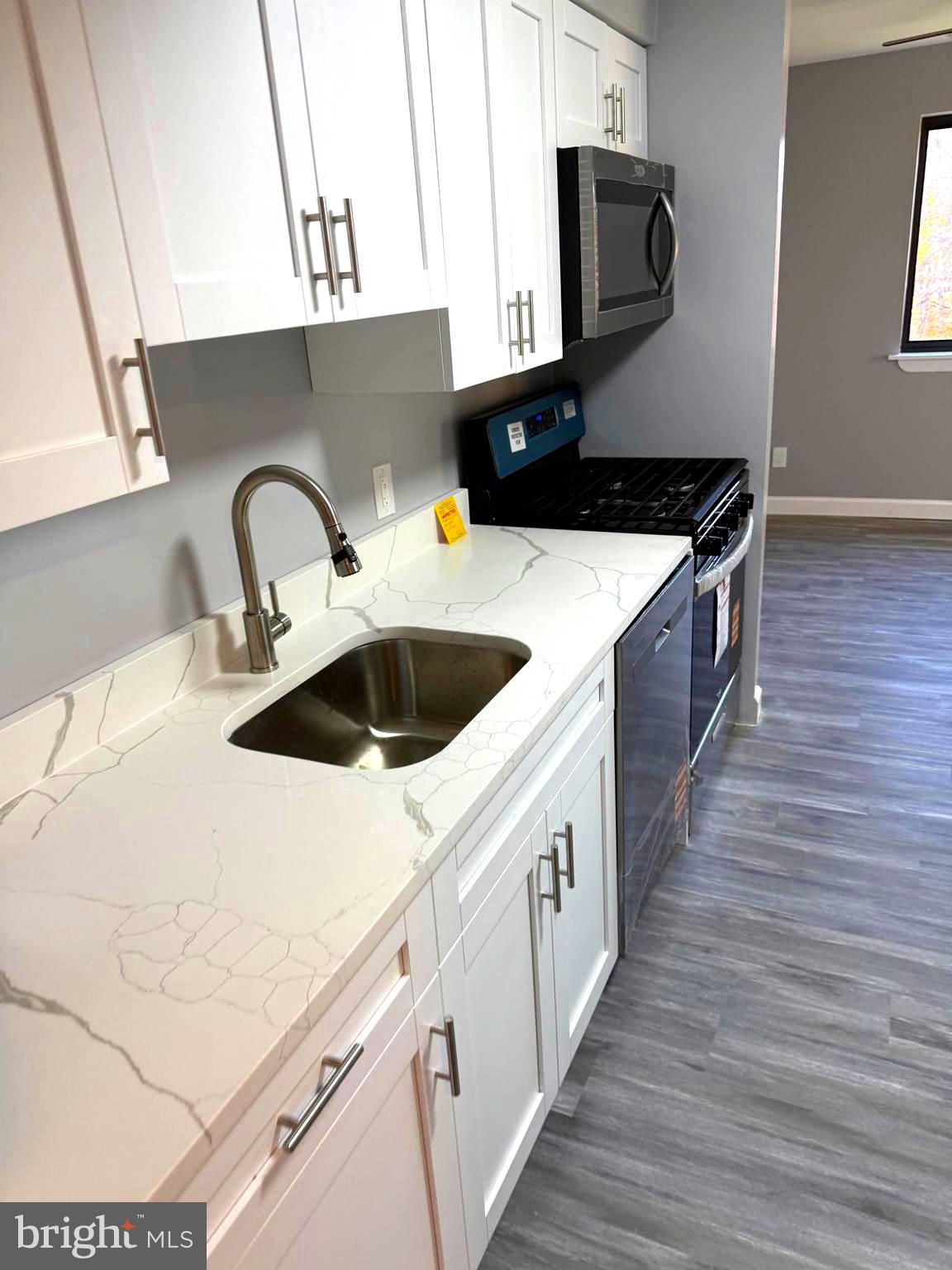 6029 Majors Lane, Unit 4 C16 Columbia, MD 21045 - Photo 32 of 51 a kitchen with a sink and wooden cabinets