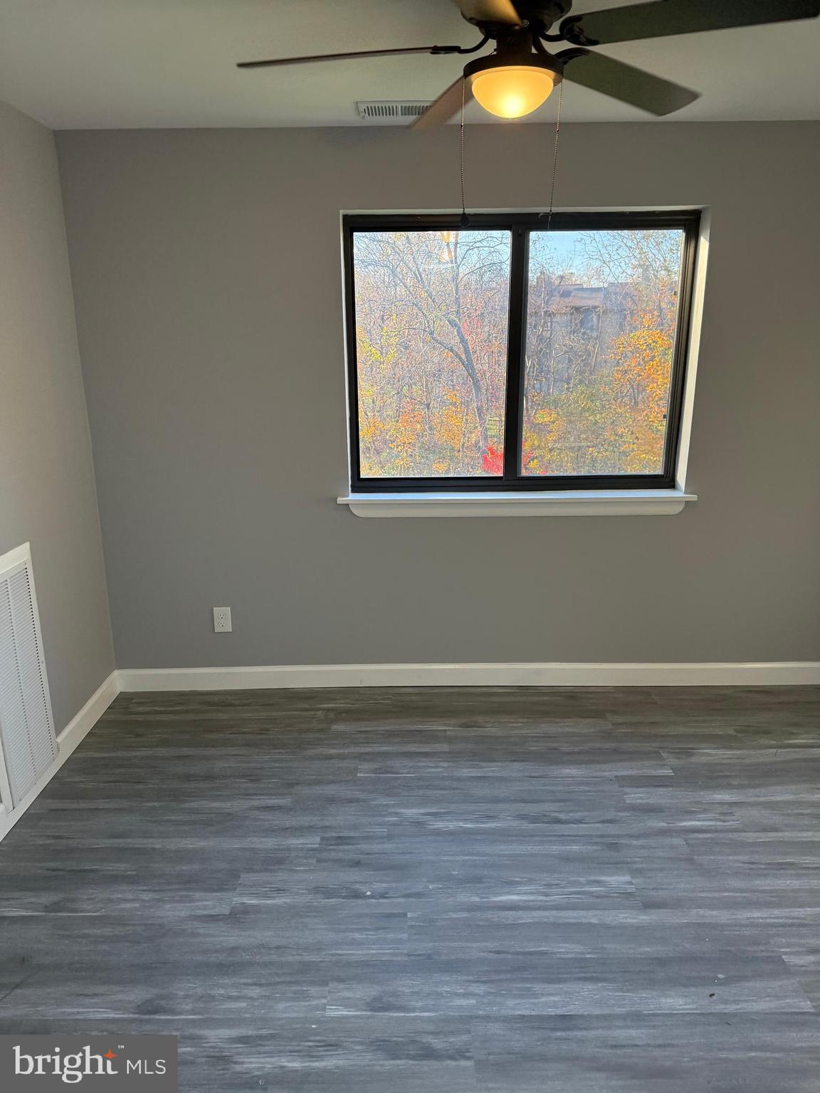 6029 Majors Lane, Unit 4 C16 Columbia, MD 21045 - Photo 38 of 51 a view of an empty room with wooden floor and a window