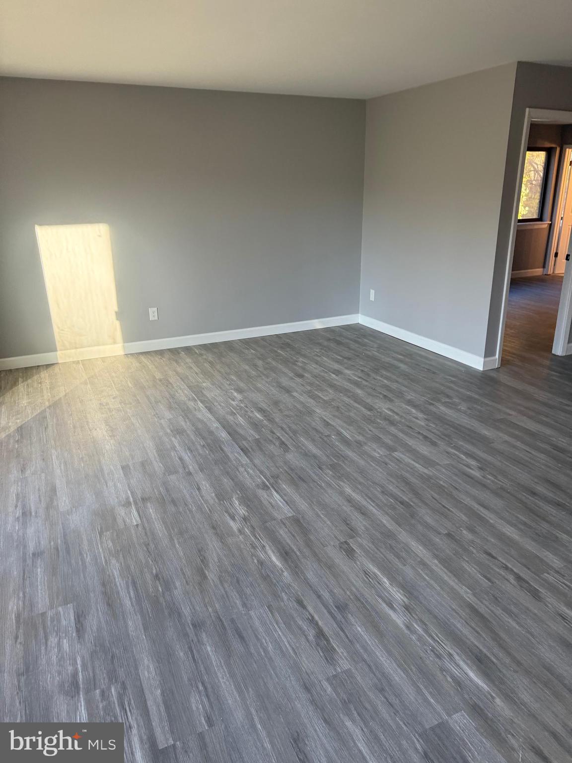6029 Majors Lane, Unit 4 C16 Columbia, MD 21045 - Photo 43 of 51 a view of an empty room with wooden floor and a window