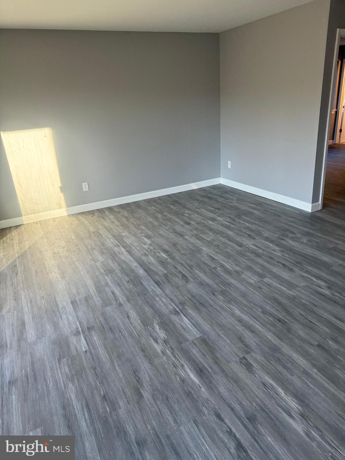 6029 Majors Lane, Unit 4 C16 Columbia, MD 21045 - Photo 44 of 51 a view of an empty room with wooden floor and a window