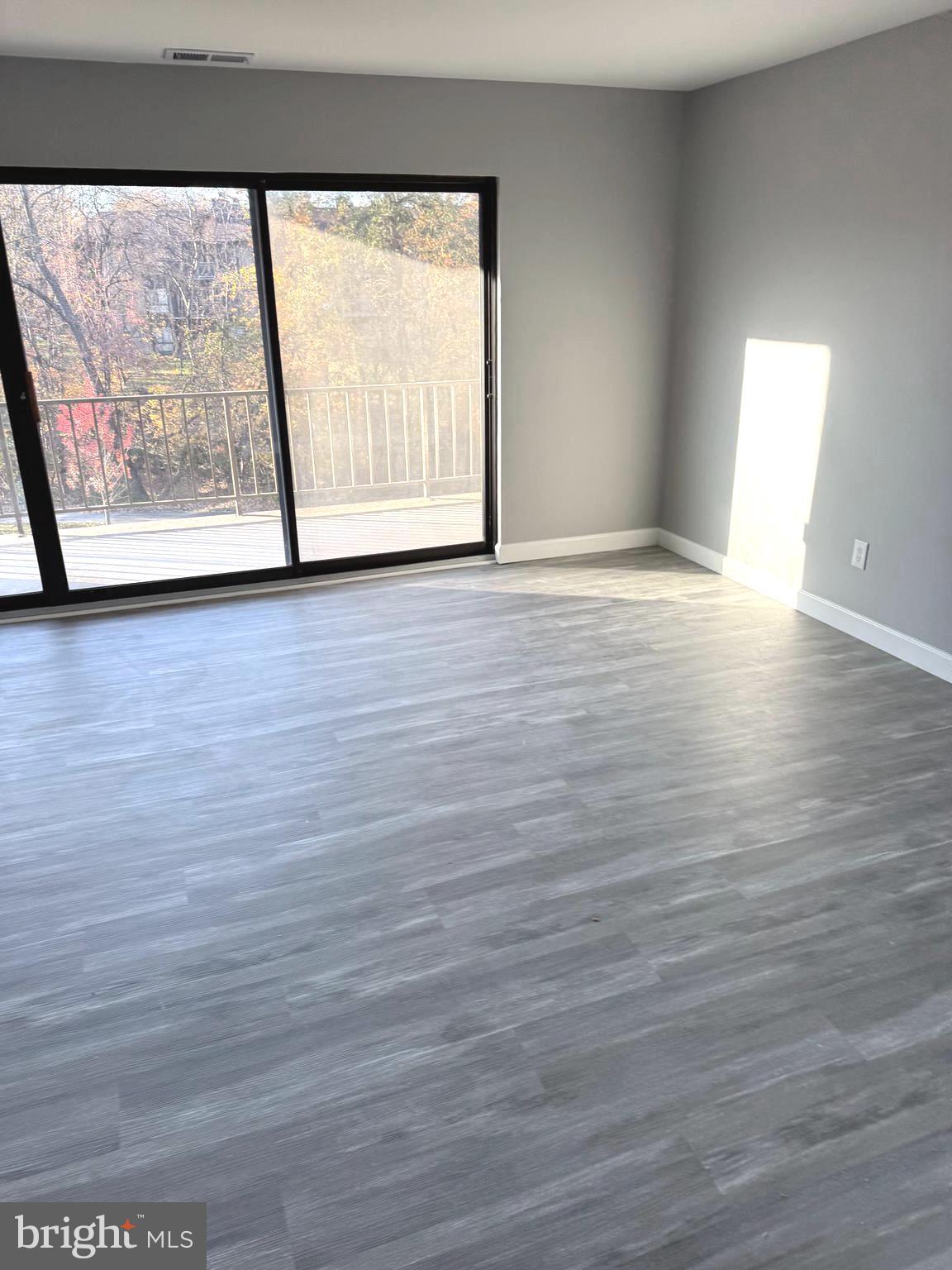 6029 Majors Lane, Unit 4 C16 Columbia, MD 21045 - Photo 10 of 51 a view of an empty room with wooden floor and a window