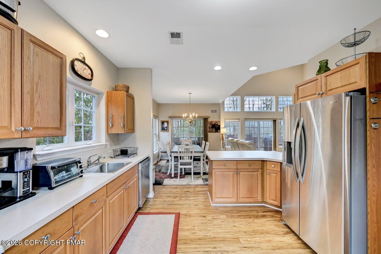 134 Skytop Road Long Pond, PA 18334 - Photo 10 of 48 a kitchen with stainless steel appliances granite countertop a refrigerator a sink dishwasher a stove and a dining table with wooden floor