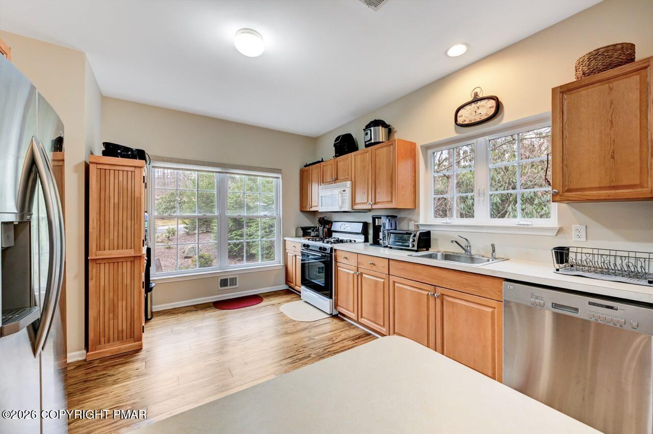 134 Skytop Road Long Pond, PA 18334 - Photo 12 of 48 a large kitchen with stainless steel appliances granite countertop a refrigerator a sink dishwasher a stove and a dining table with wooden floor
