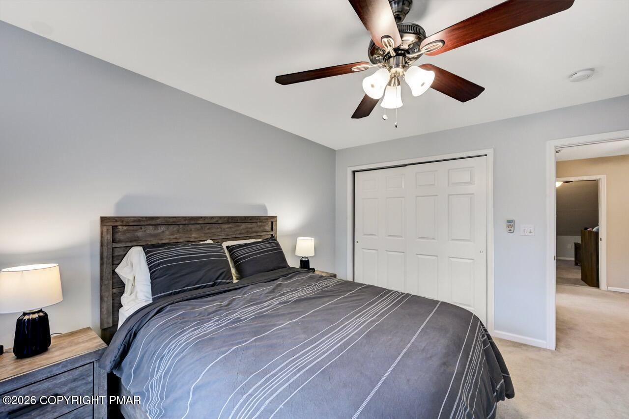 134 Skytop Road Long Pond, PA 18334 - Photo 24 of 48 a bedroom with a bed and a chandelier