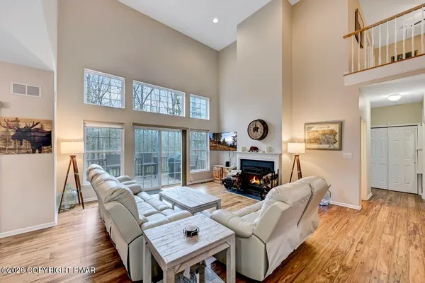 a living room with furniture a fireplace and a floor to ceiling window