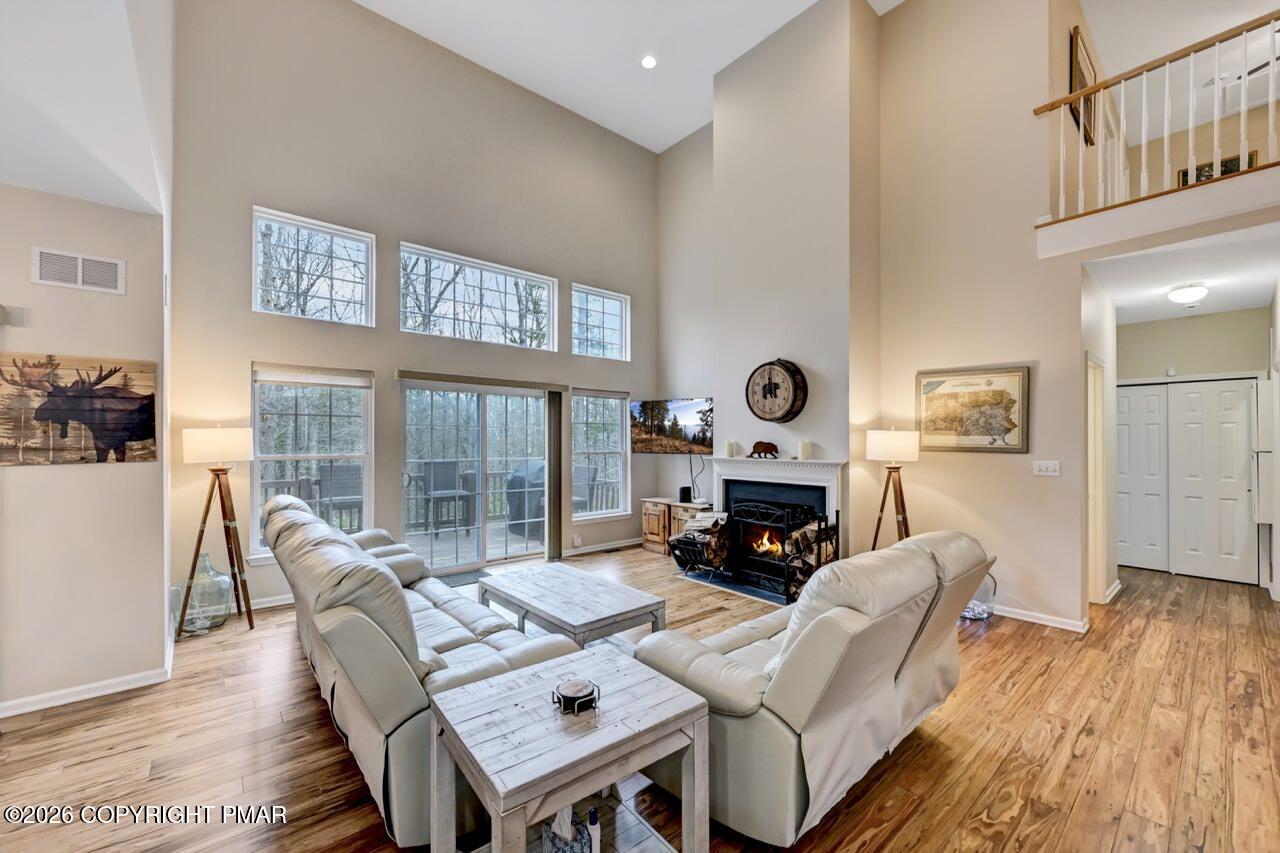 134 Skytop Road Long Pond, PA 18334 - Photo 5 of 48 a living room with furniture a fireplace and a floor to ceiling window