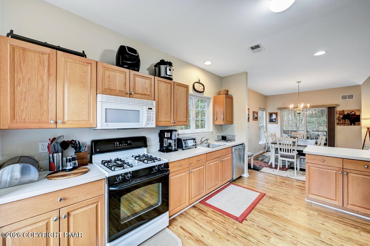 134 Skytop Road Long Pond, PA 18334 - Photo 9 of 48 a kitchen with stainless steel appliances granite countertop a stove a sink dishwasher and a microwave oven with cabinets