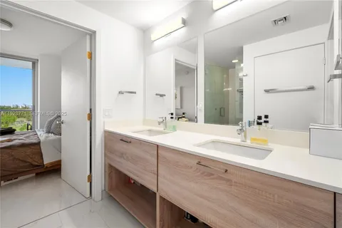 a spacious bathroom with a double vanity sink a mirror and a bathtub