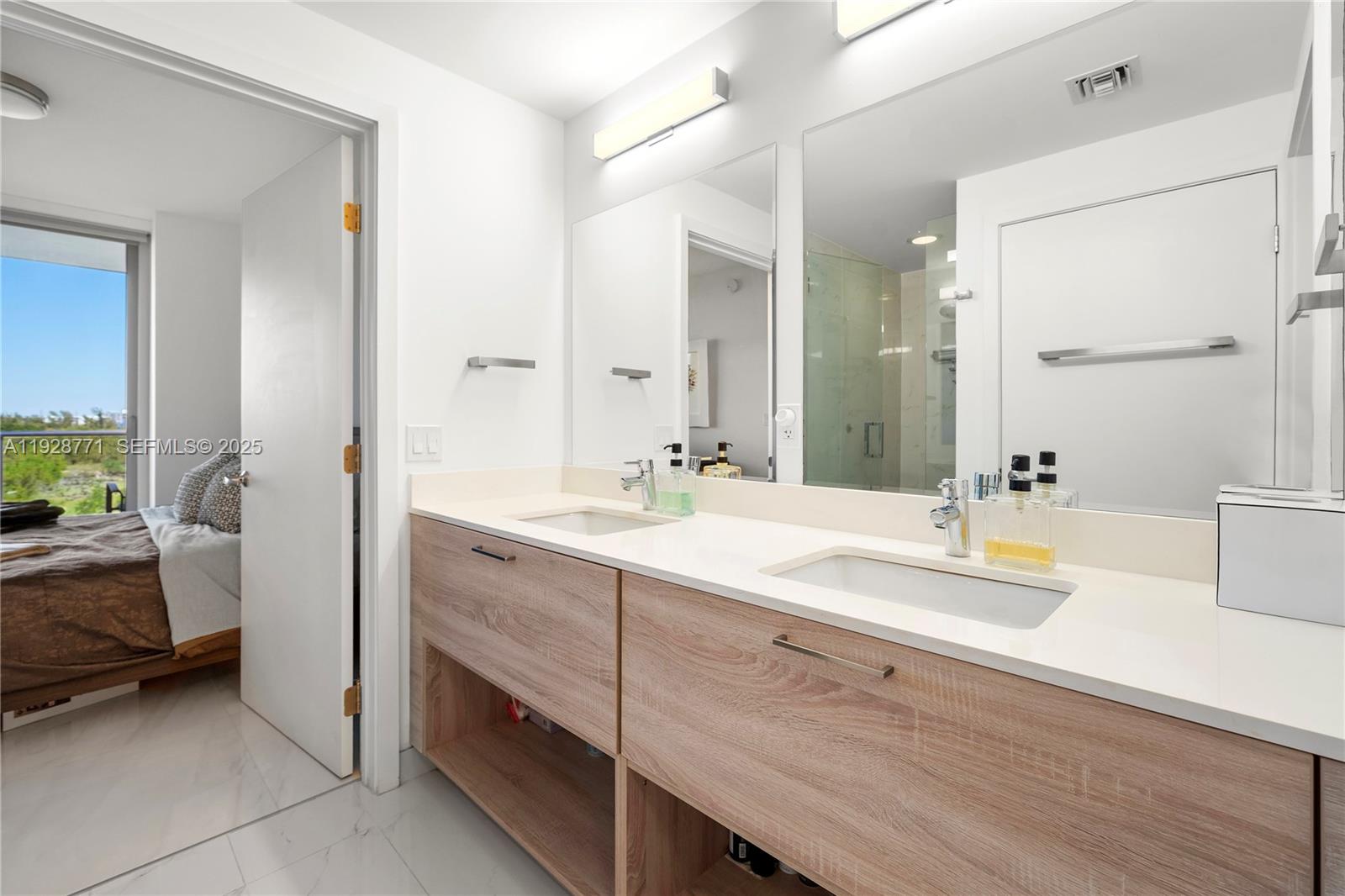 16385 Biscayne Boulevard, Unit 503 North Miami Beach, FL 33160 - Photo 11 of 50 a spacious bathroom with a double vanity sink a mirror and a bathtub