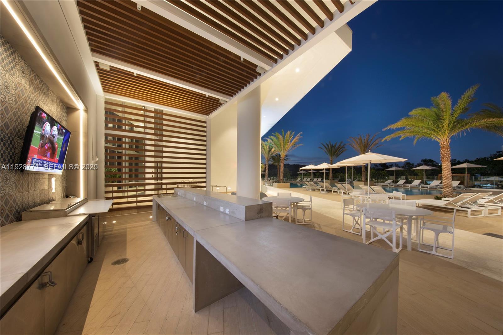 16385 Biscayne Boulevard, Unit 503 North Miami Beach, FL 33160 - Photo 31 of 50 a view of a patio with table and chairs under an umbrella with wooden floor
