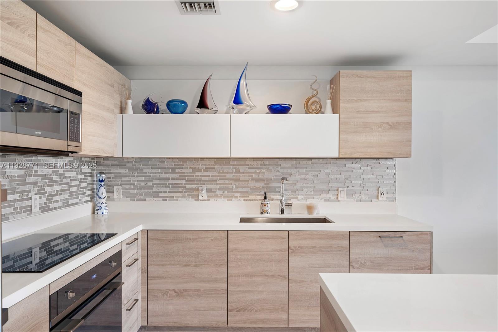 16385 Biscayne Boulevard, Unit 503 North Miami Beach, FL 33160 - Photo 7 of 50 a kitchen with sink cabinets and stove