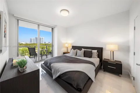 a bedroom with a bed lamp and a potted plant