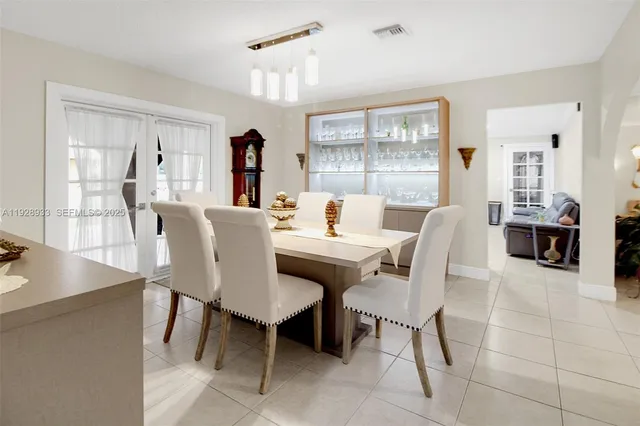 a kitchen with stainless steel appliances a refrigerator a table and chairs
