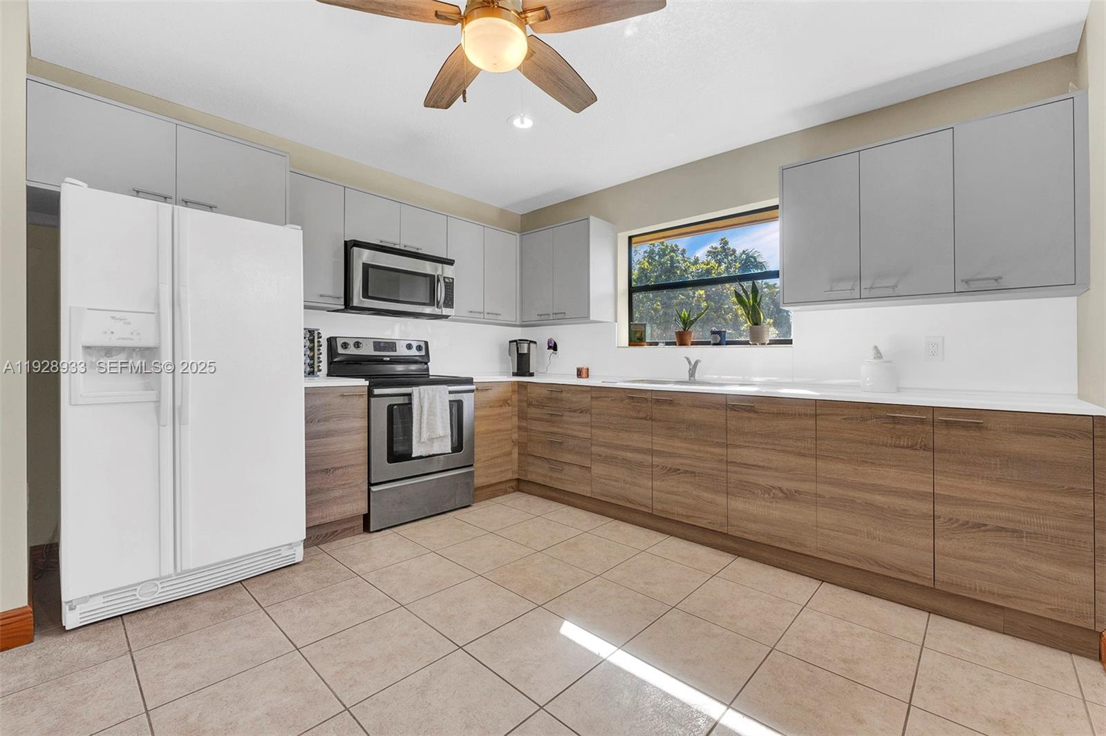 50 Southwest 130th Avenue Miami, FL 33184 - Photo 49 of 70 a kitchen with stainless steel appliances kitchen island granite countertop a refrigerator and a sink
